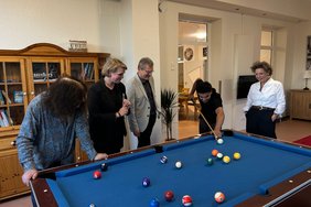 Lena Lenz und Rüdiger Schewe-Strahl (Martinigruppe), Burkhard Hillers (Sparkasse Münsterland Ost), ein Bewohner der Martinigruppe sowie Dr. Martina Klein (Leitung Fundraising Alexianer) bei der Übergabe des Billardtischs in der Martinigruppe.