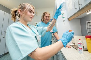 Eine Auszubildende stellt unter Aufsucht eine Infusion her