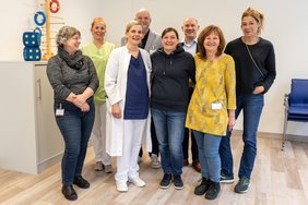 Mehrere Personen stehen in einem modernen Therapieraum