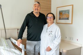 Zwei Personen stehen an einem Krankenbett