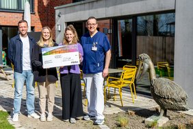 Vier Personen stehen auf einer Terrasse