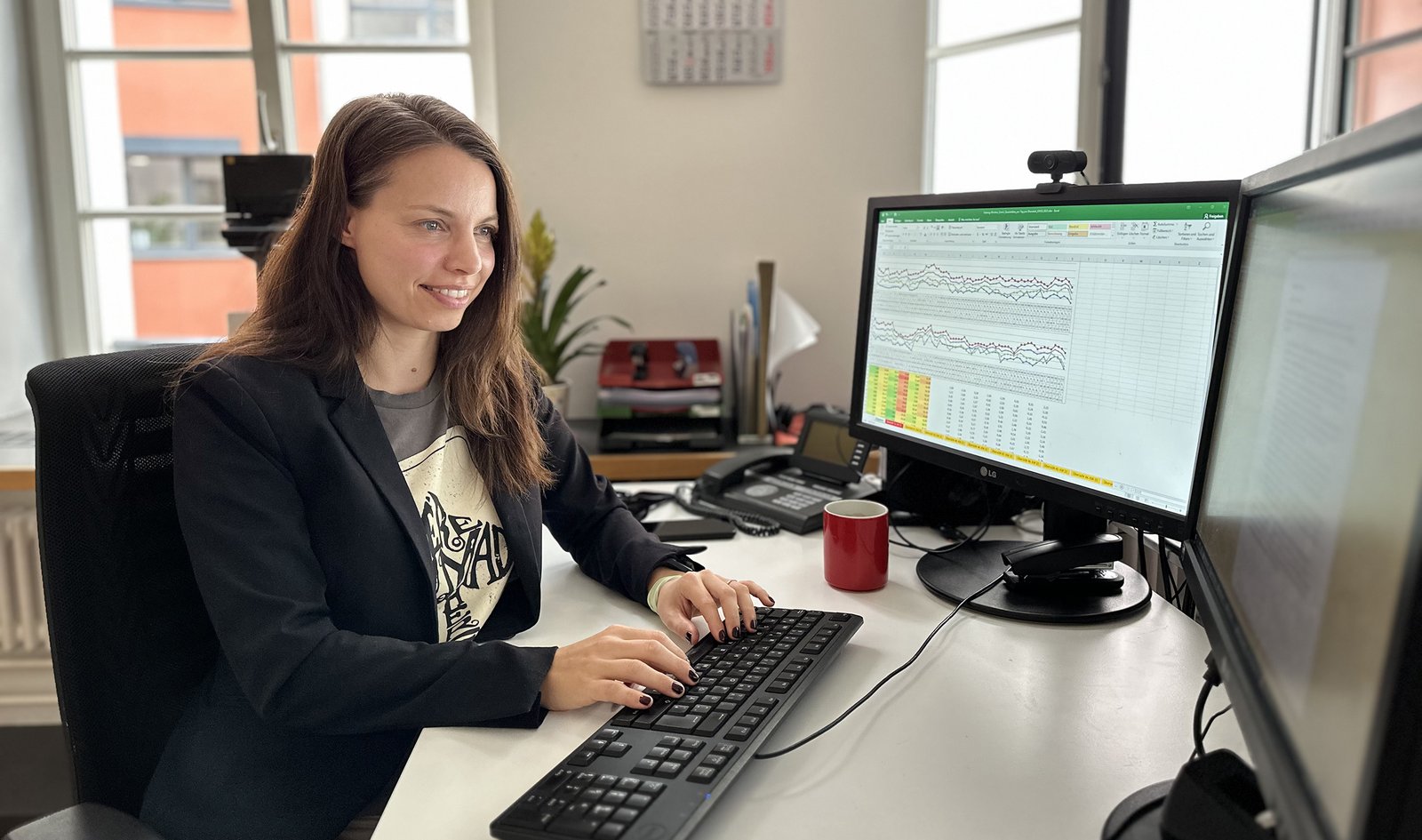 Mitarbeiterin am Schreibtisch vor dem PC