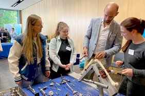 Vier weibliche Pflegekräfte arbeiten unter Anleitung an einem Knochenmodell