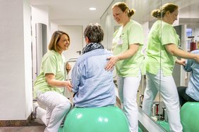Zwei Therapeutinnen arbeiten mit einer Patientin