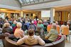 Viele Menschen sitzen im Foyer der Raphaelsklinik und verfolgen einen Vortrag