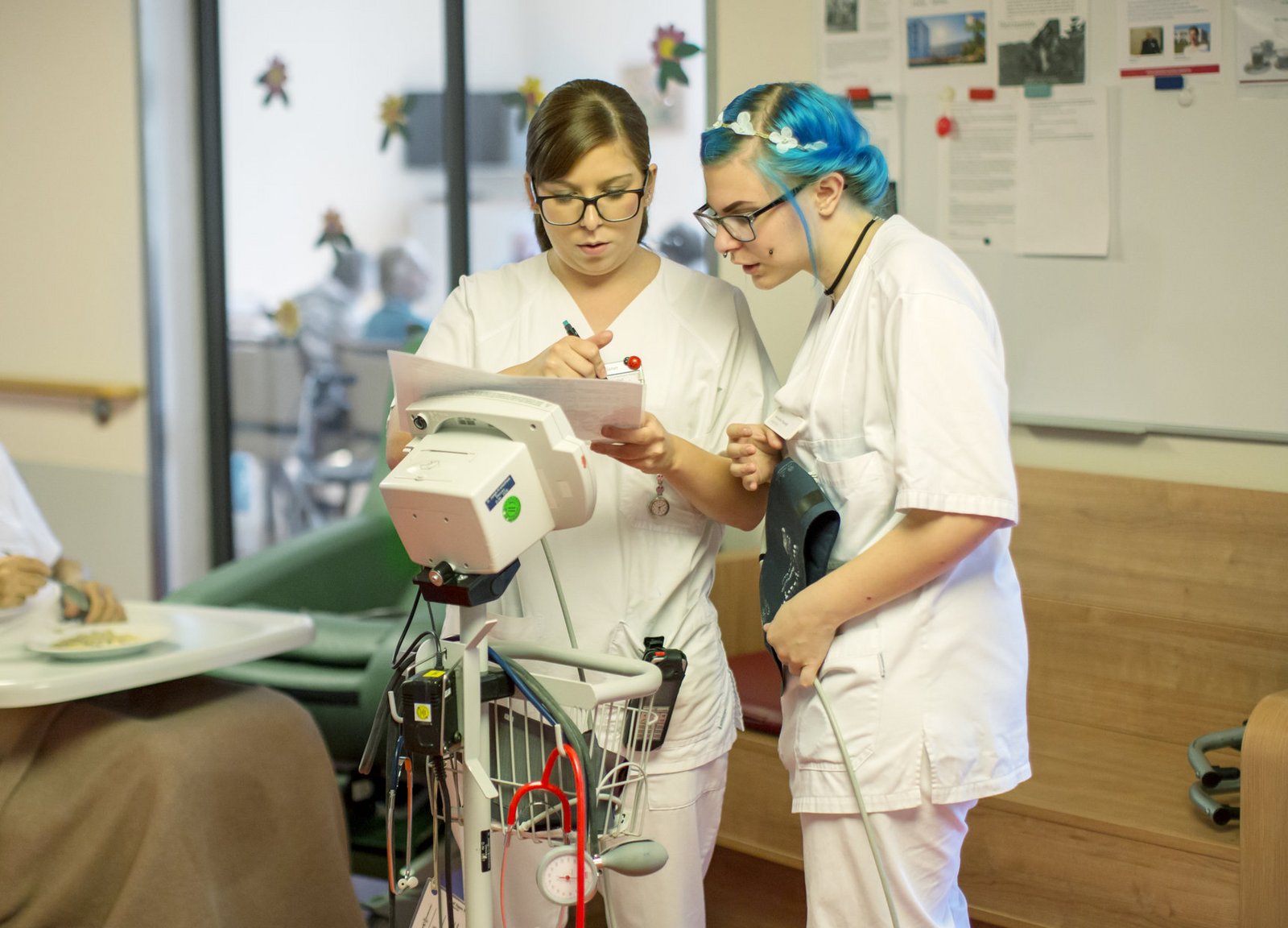 Pflegerinnen lesen Patientenstatus aus