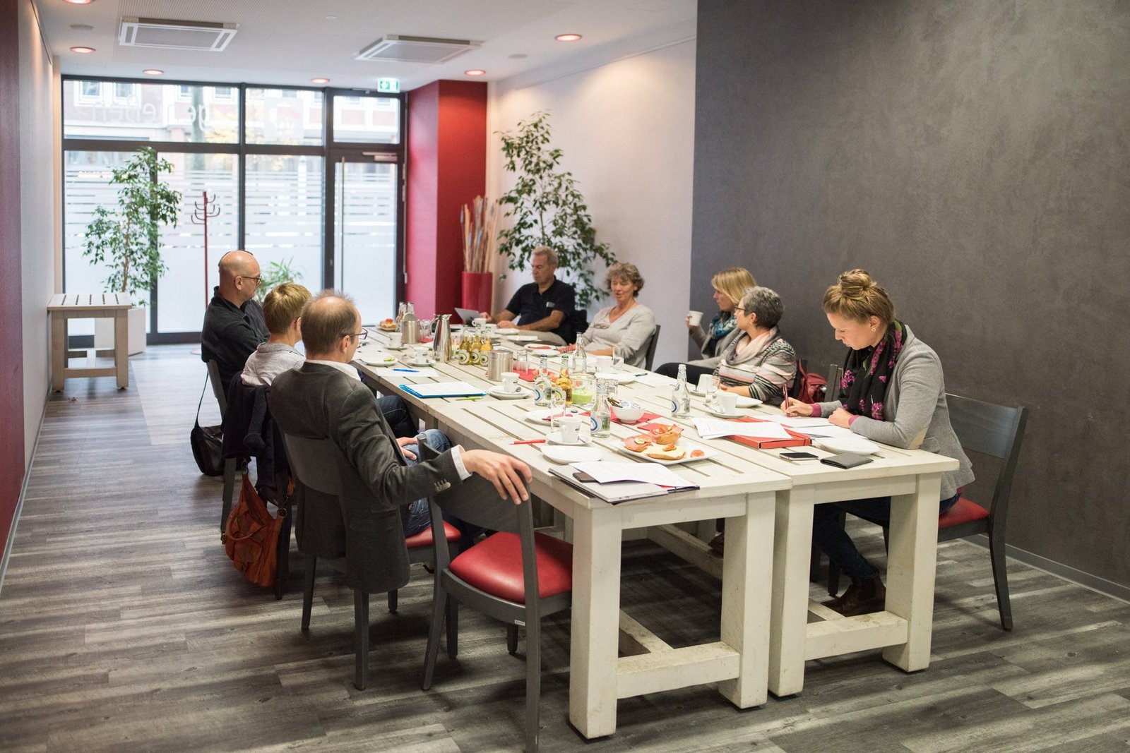 Menschen sitzen an einem Café-Tisch und diskutieren