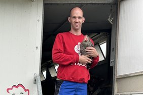 Ron mit einem Huhn auf dem Arm
