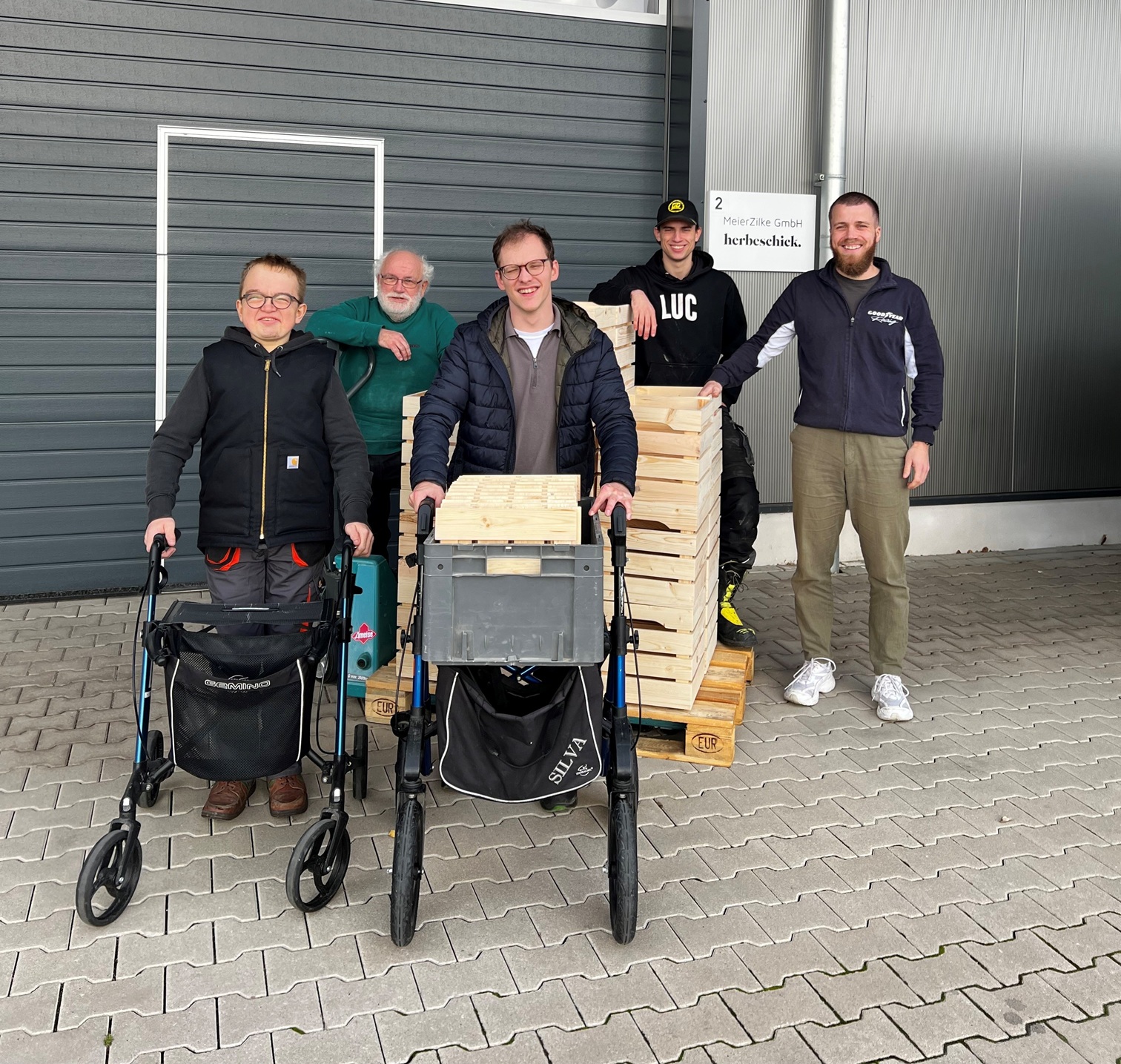 Ein starkes Stück Handarbeit: Teilnehmende der Alexianer START GmbH übergaben die ersten individuell gefertigten Holzkisten an Herbeschick-Geschäftsführer Andreas Zilke (re.) – ein sichtbares Ergebnis gelungener Inklusion und Zusammenarbeit.